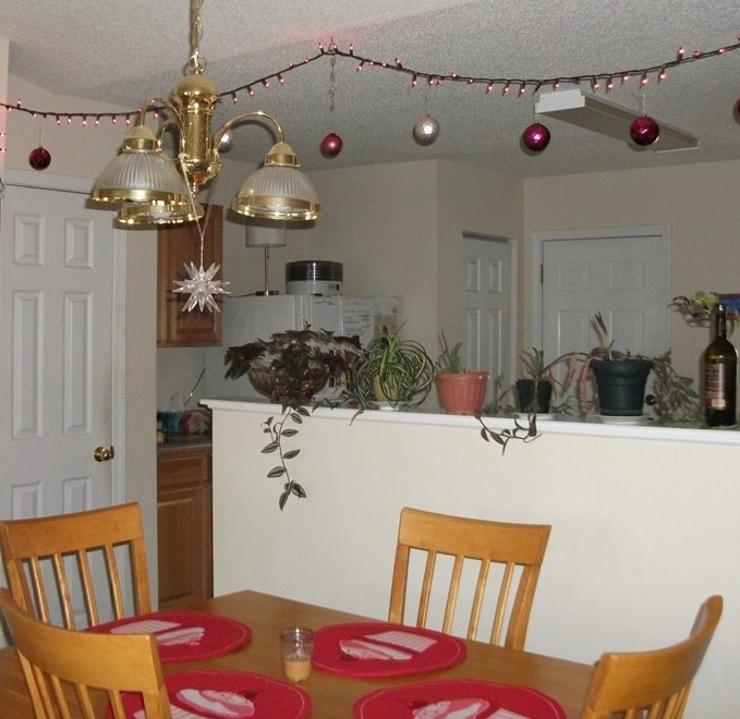 Purple and silver holiday balls can hang from a pink/purple light strand over a table donned with Valentine's Day placemats
