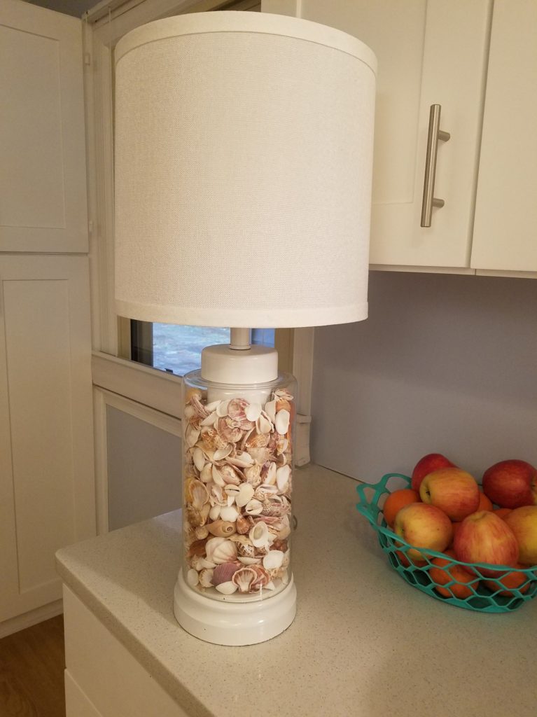 Lamp with shell-filled clear base, from furniture consignment store