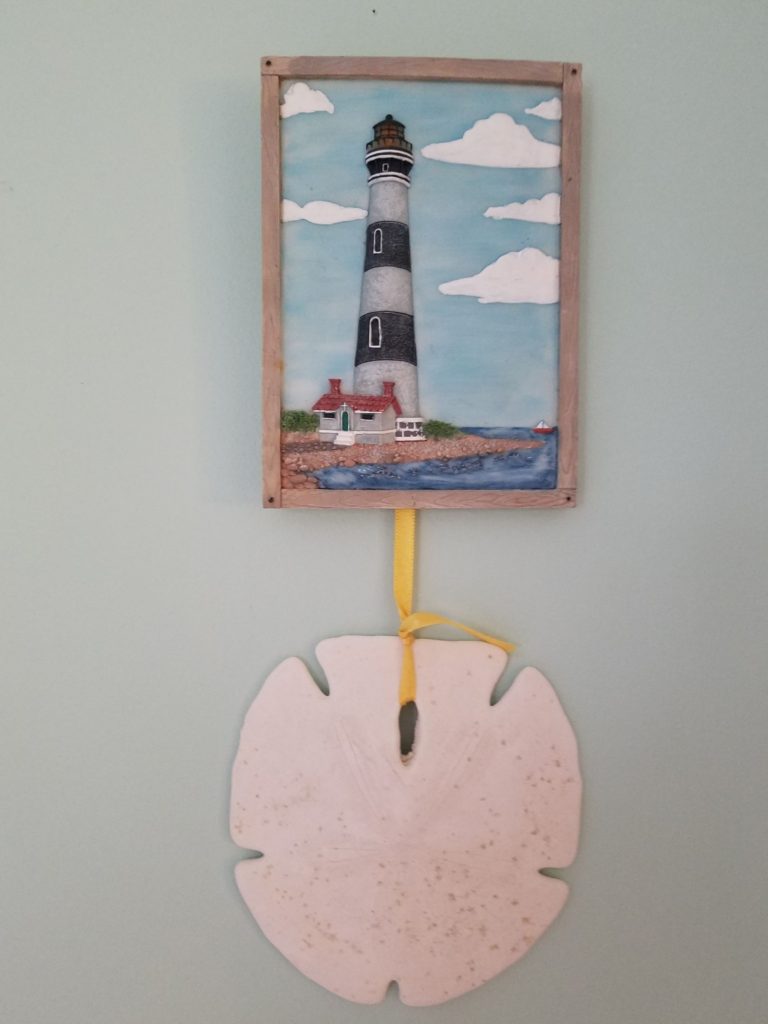 Lighthouse carved picture, from thrift store with sand dollar hung beneath