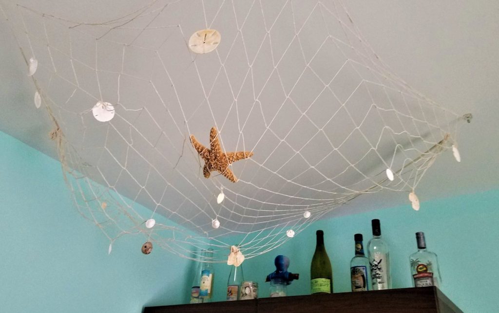 Fishing net hung from ceiling with shells, from thrift craft store