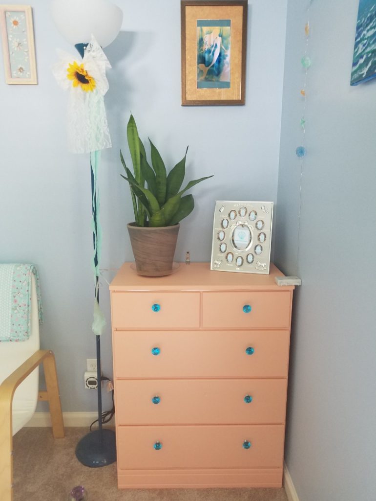 Create a calm nursery with soft colours: painted dresser with sky blue glass knobs