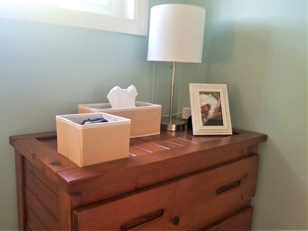 Small peach storage bins bring pleasant colour to a brown dresser top