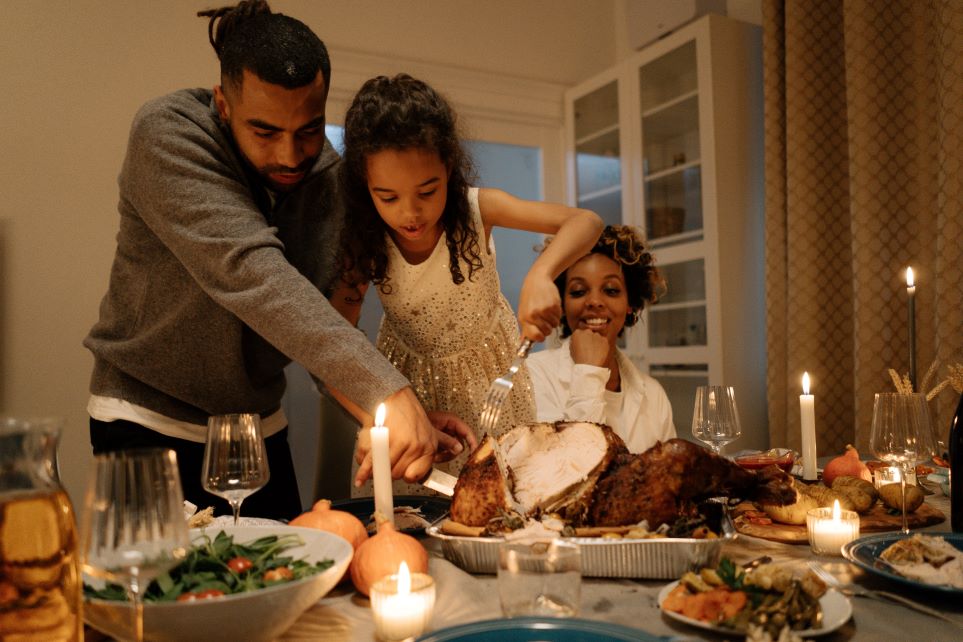 Family carving turkey at Thanksgiving meal