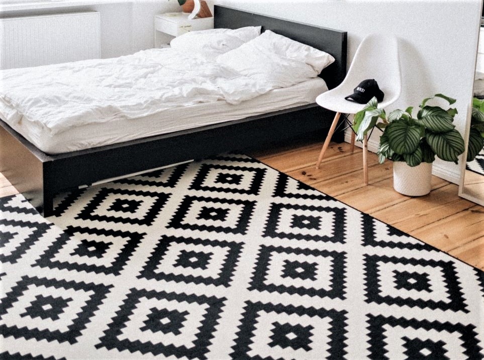 Bedroom with black and white geometric diamond-patterned area rug
