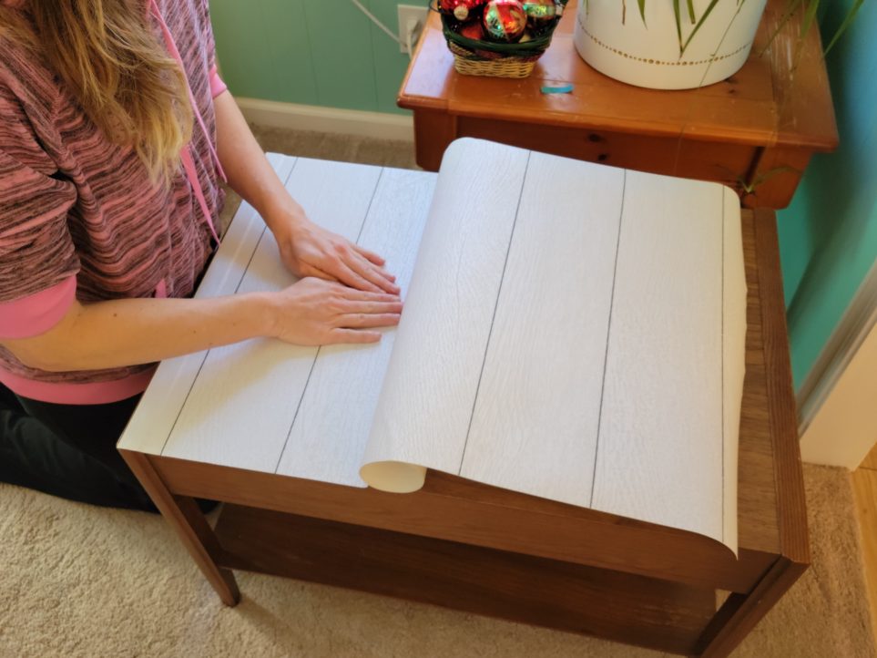 Smoothing paper onto surface from middle toward sides