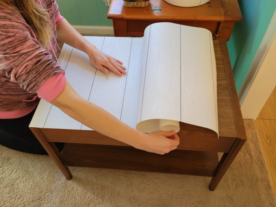 Peeling paper backing down while pressing forward