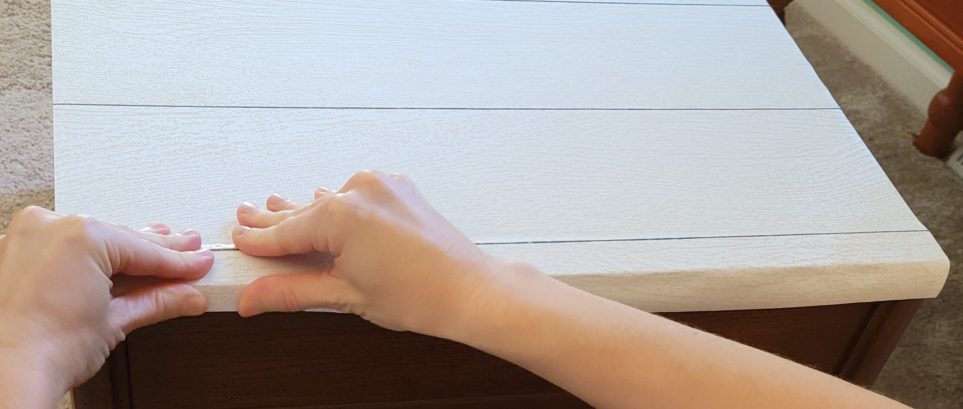 Flattening paper down over bottom of edge lip