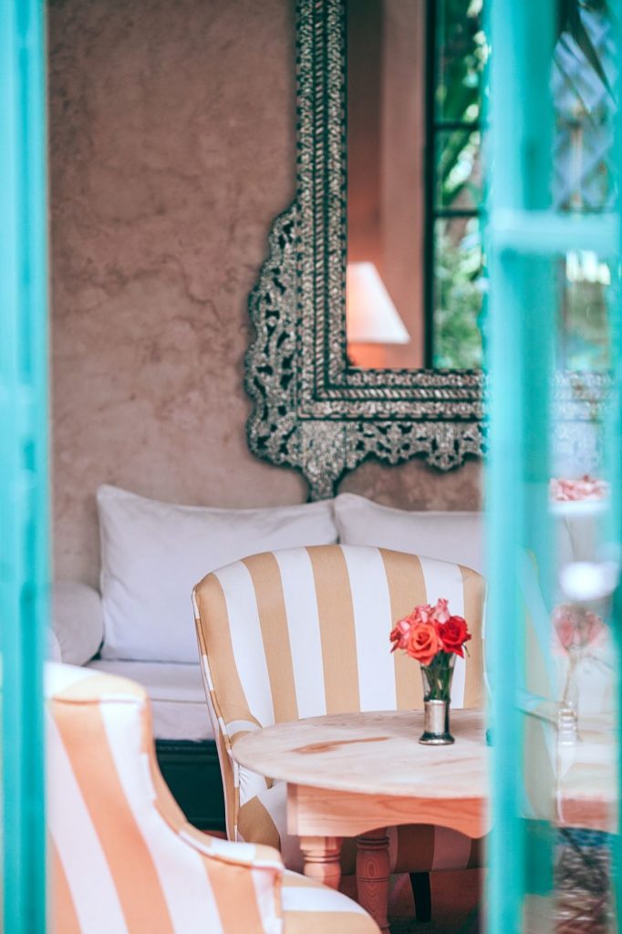 A colorful home with pink and white striped chairs