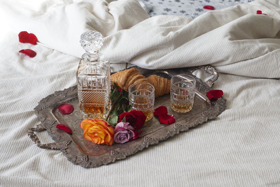 Cozy spot with a tray, croissants, and bevvy on the bed