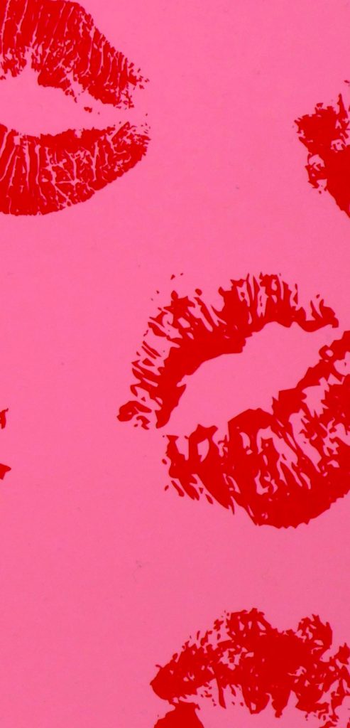 Iconic lovecore red lipstick imprints on hot pink background