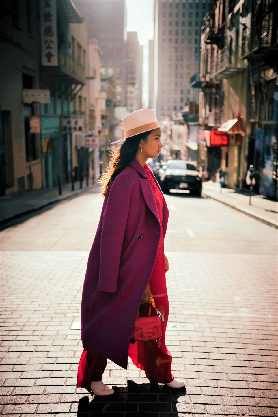 Woman dressed in lovecore style with fuchsia coat and pink romper