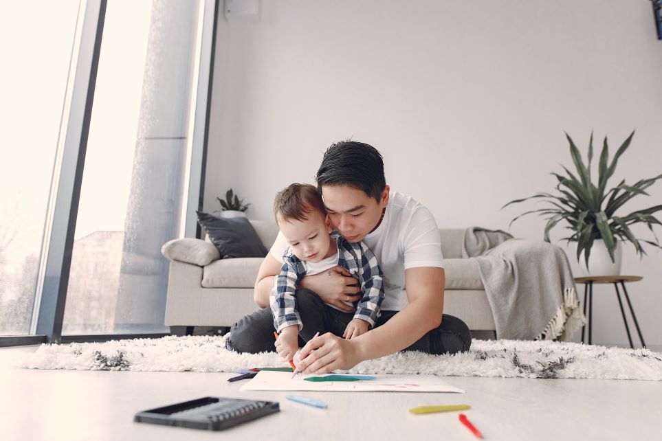 Dad helping toddler draw