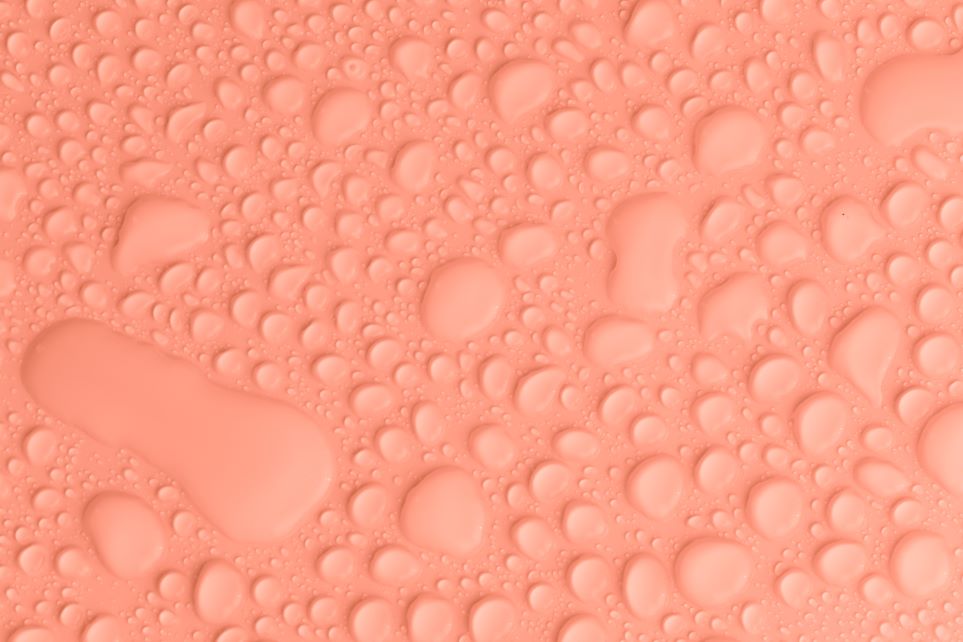 light salmon colored surface covered in water droplets