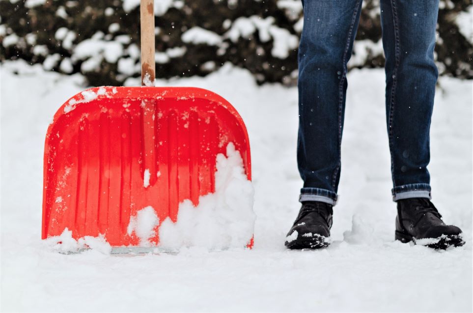 Photo of person with snow shovel. Parenting at a challenging time can involve days with no safe roads
