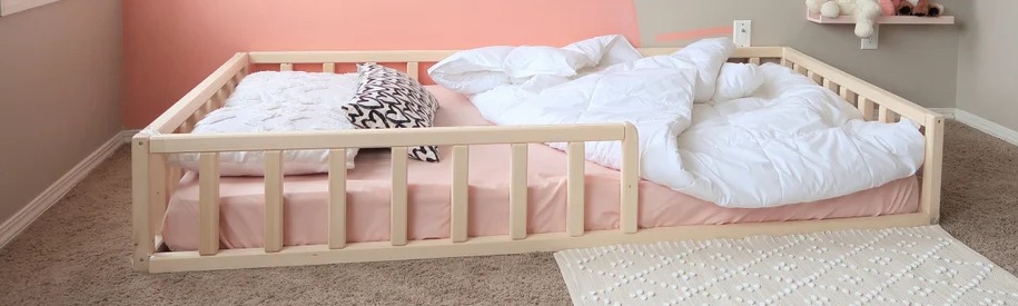 Montessori floor bed with rails and white comforter