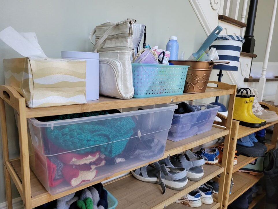 Balance the stuff/space ratio with smart organization like tall tiered shoe racks as seen in this photo with shoes on lower shelves and bins on top two shelves with everyday grab-and-go essentials, purse, tissues, and other items kept organised in one place