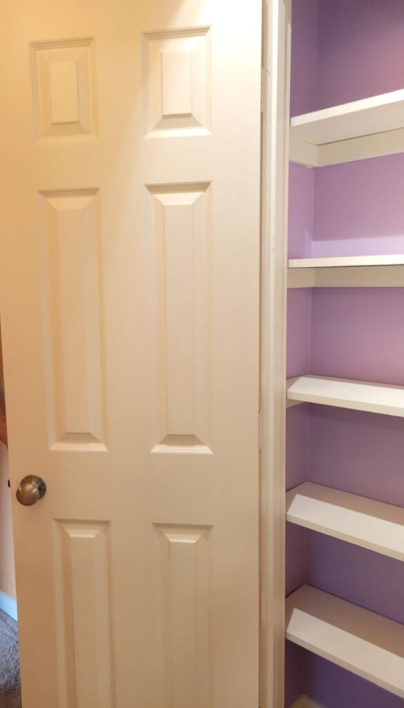 An open linen closet at the old house reveals white-painted wood shelves inside a shallow closet with periwinkle-painted walls. Even closets can become beloved creative spaces for storing towels