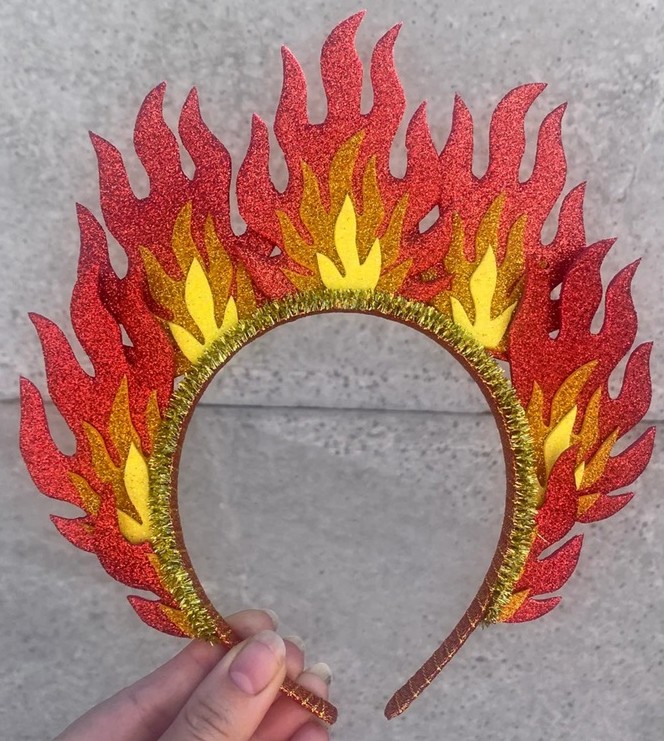 A headband with red, orange and yellow glitter flames sticking up like a fiery crown