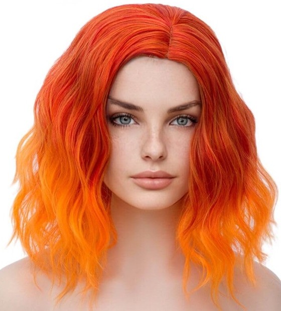 Close-up photo of a realistic mannequin wearing an ombre flame coloured wig with wavy layers of medium length with bright orange tips fading up to darker neon vivid orange roots.