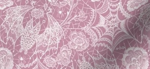Close-up photo showing bat and spiderweb detailing in pink Halloween lace