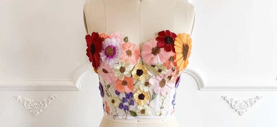 A beautiful flower-embroidered corset on a sewing mannequin