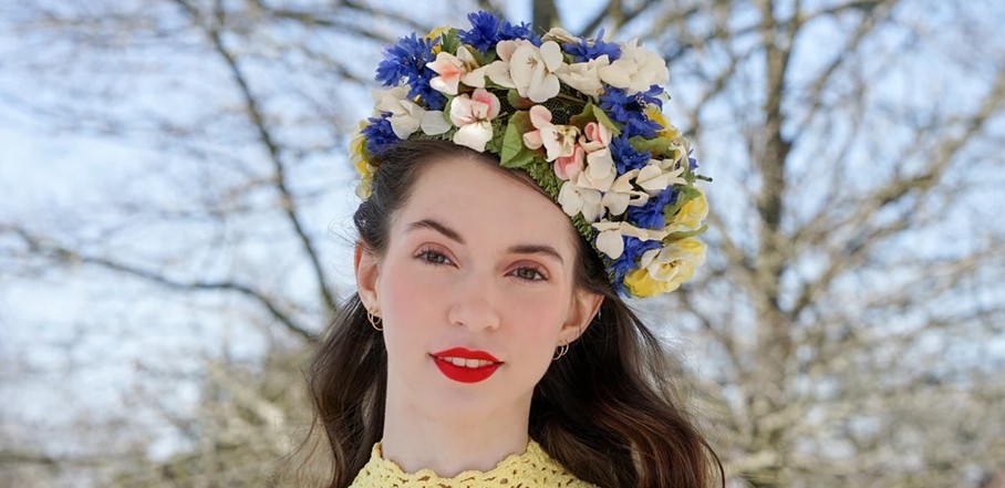 A model wears a 1960s vintage Schiaparelli floral pillbox hat covered in flowers