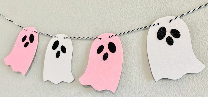 Close-up photo of a Halloween garland with alternating glitter cardstock pink and white ghosts