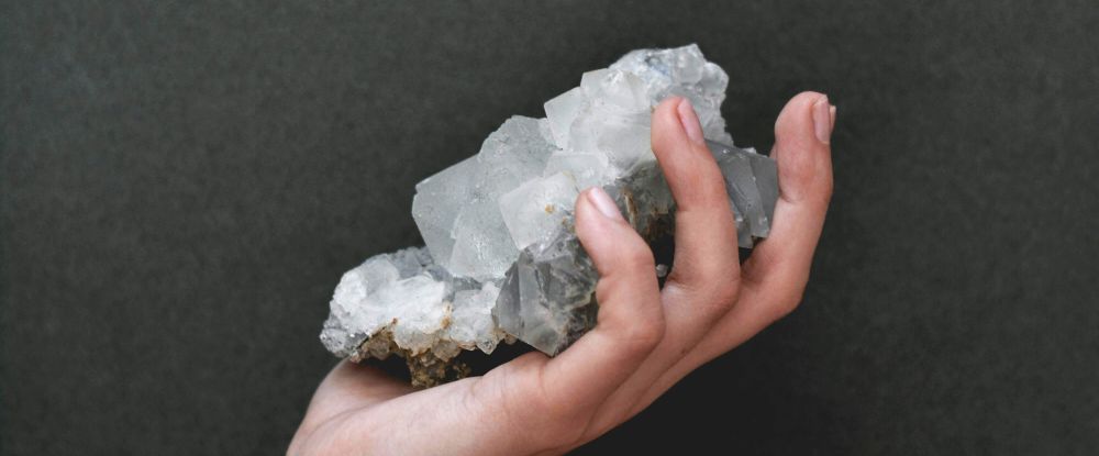 Person holding raw cluster of apophyllite, filling their palm