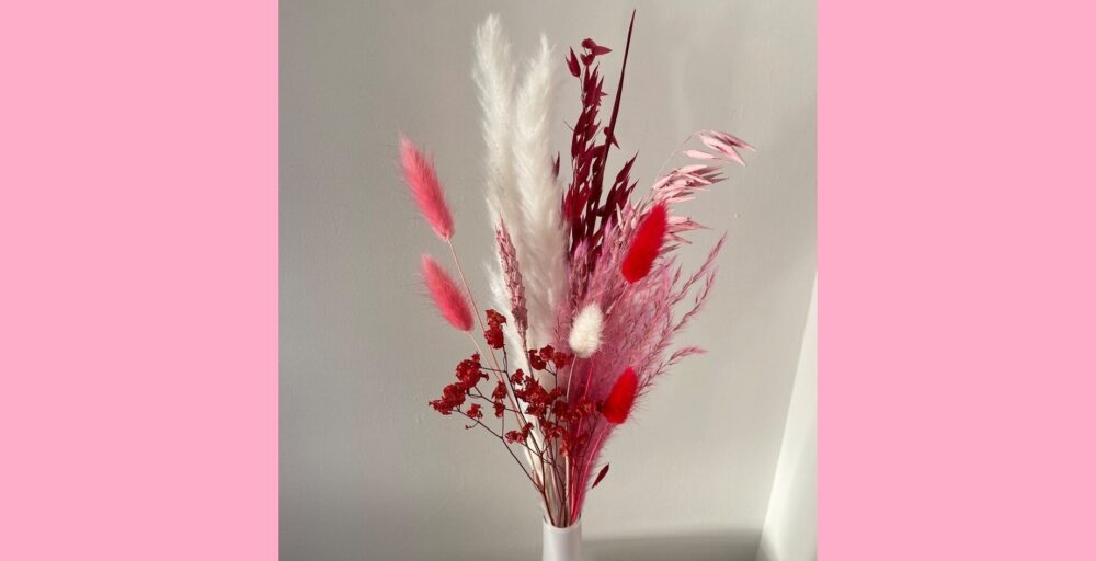 Fresh-cut flowers are beautiful lovecore decor but the dried flower bouquet seen in this photo is just as lovely and includes wheat, grasses, cattails, and other natural materials dyed in berry red, white and pink.