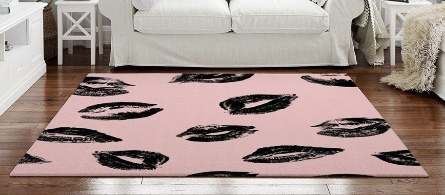 A pale pink area rug with black lipstick kisses pattern