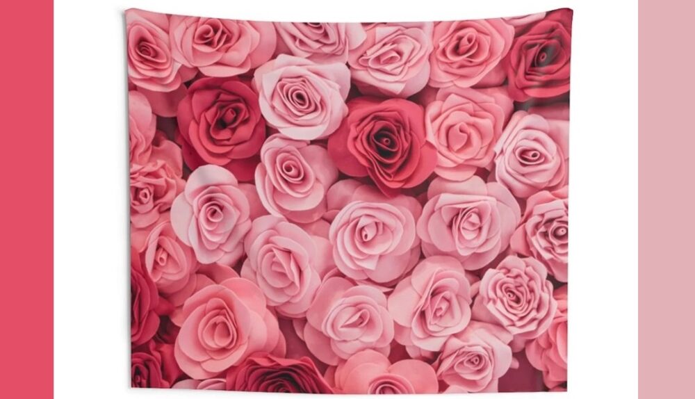 A large tapestry of a close-up image of pink roses in various hues of pink hangs on a white background