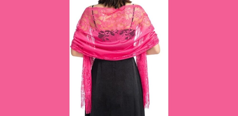 model seen from behind wearing a lacy pink shawl over her shoulders over a black dress