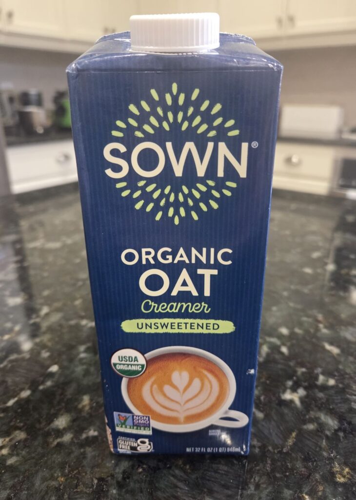 A small carton of SOWN brand unsweetened organic oat creamer atop a kitchen counter