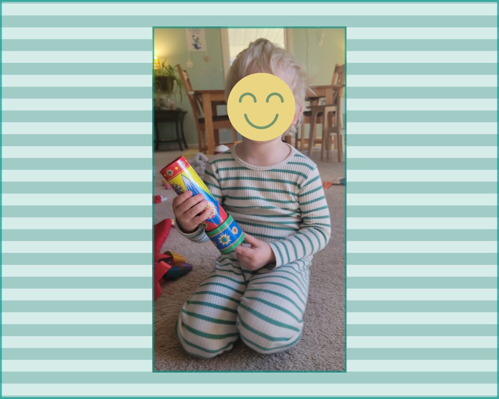 Photo set in center of a design with light green and pale green stripes (to match the pyjamas) and outlined in a thin matching green frame. Photo shows a toddler wearing cute, comfortable ivory-and-mint-striped pyjamas, and a graphic yellow smiley face overtop his face for internet privacy