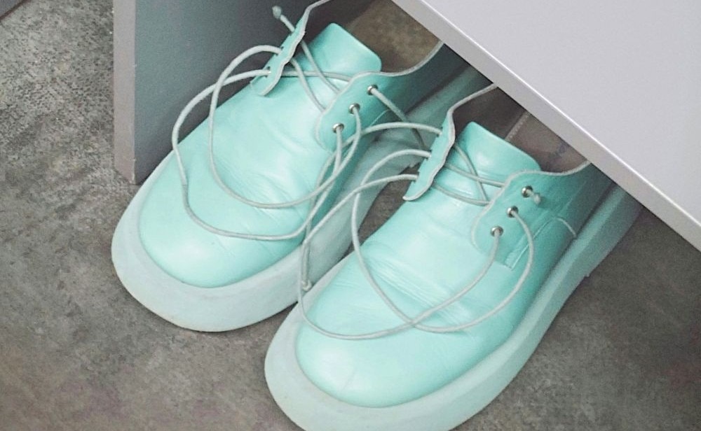 A pair of comfortable light mint green shoes in Râmnicu Vâlcea, Romania with generous toe beds, white soles, and thin white laces