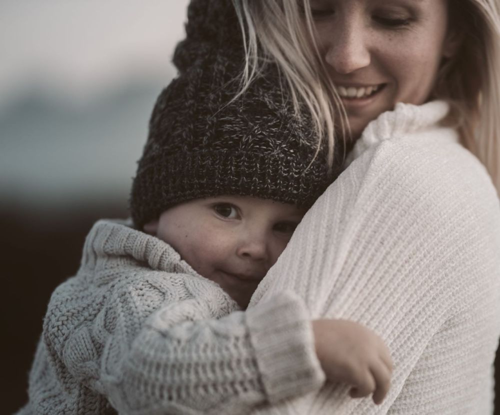 A mom snuggles her baby boy in her arms