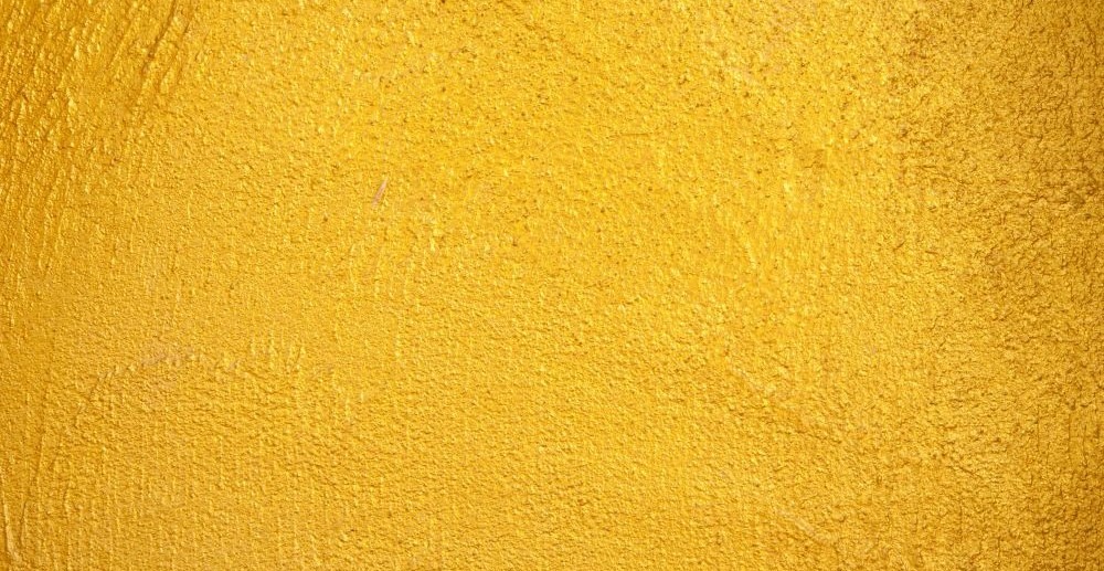 Close-up photo of a vibrant yellow/gold-painted surface