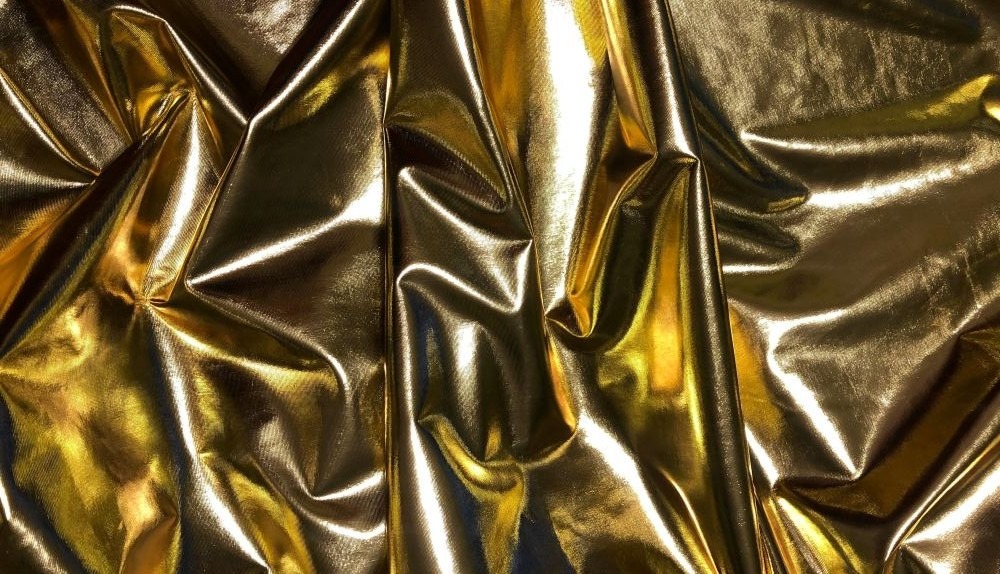 Close-up photo of metallic gold-coloured textile bunched up in folds