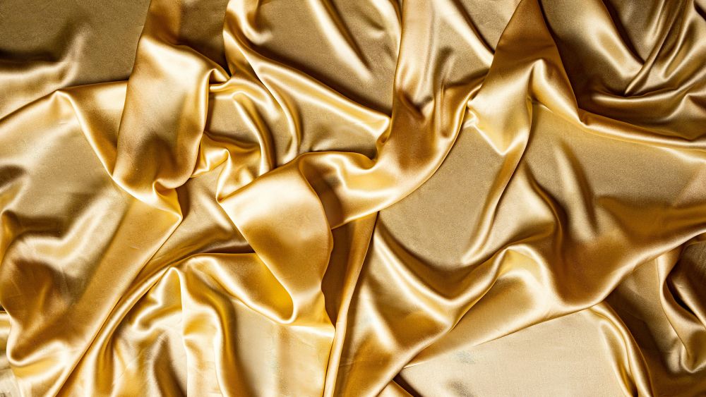 Close-up photo of crumpled gold-coloured satin fabric